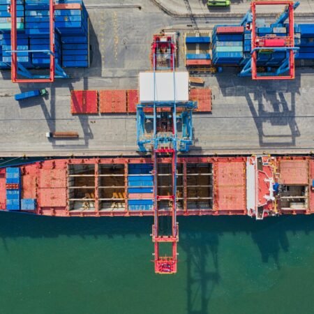Drone shot of cargo ship and containers at North Jakarta port, illustrating trade and transportation.