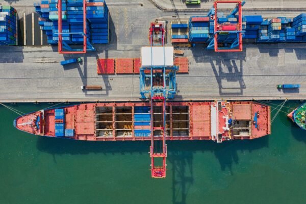 Drone shot of cargo ship and containers at North Jakarta port, illustrating trade and transportation.