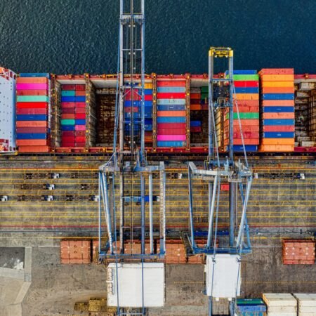 Aerial view of colorful cargo containers at a bustling port in Jakarta, Indonesia.